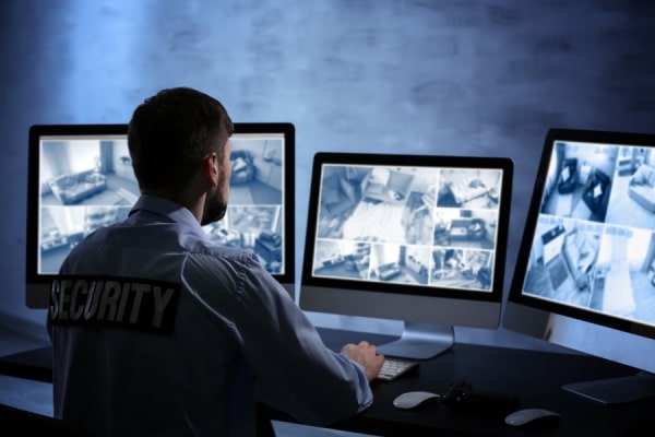 Ein Security-Mitarbeiter guckt auf Bildschirme
